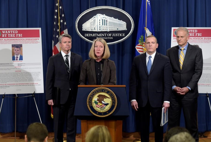 Acting Assistant Attorney General Mary McCord, second from left, speaks during a news conference at the Justice Department in Washington, Wednesday, March 15, 2017.