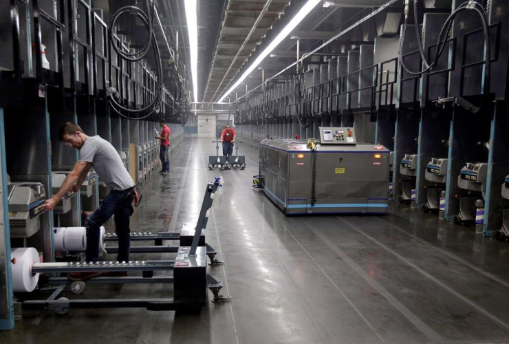 Workers and robots labour side-by-side with plastic thread made from recycled bottles at the Repreve Bottle Processing Center, part of the Unifi textile company in Yadkinville, N.C., in an October 21, 2016,