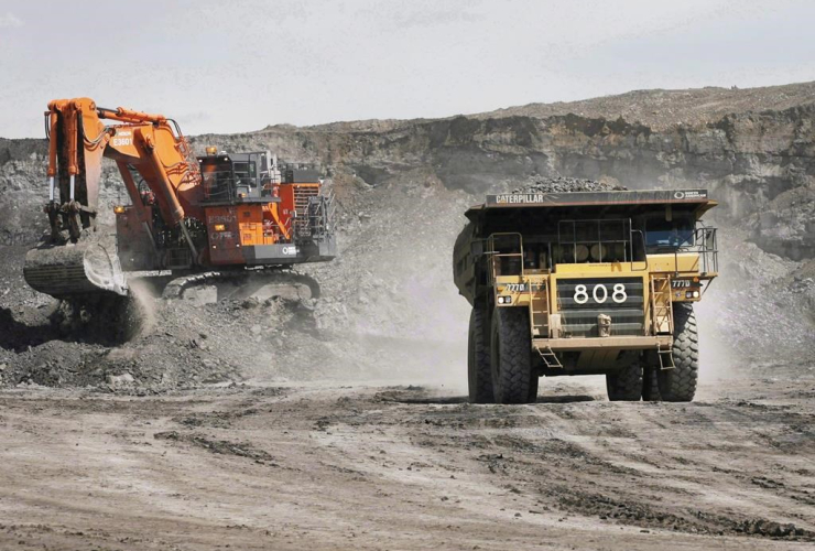 A haul truck carrying a full load drives away from a mining shovel at the Shell Albian Sands oilsands mine near Fort McMurray, Alta., on Monday.July 9, 2008