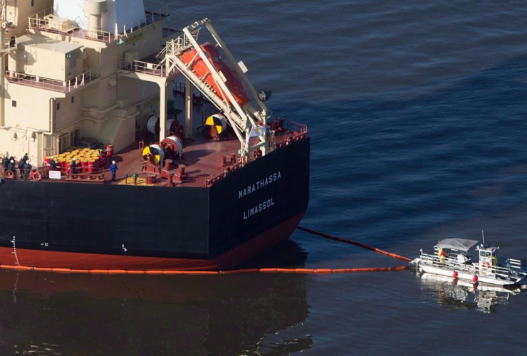 A spill response boat secures a boom around the bulk carrier cargo ship MV Marathassa after a bunker fuel spill in Vancouver, B.C., on April 9, 2015.