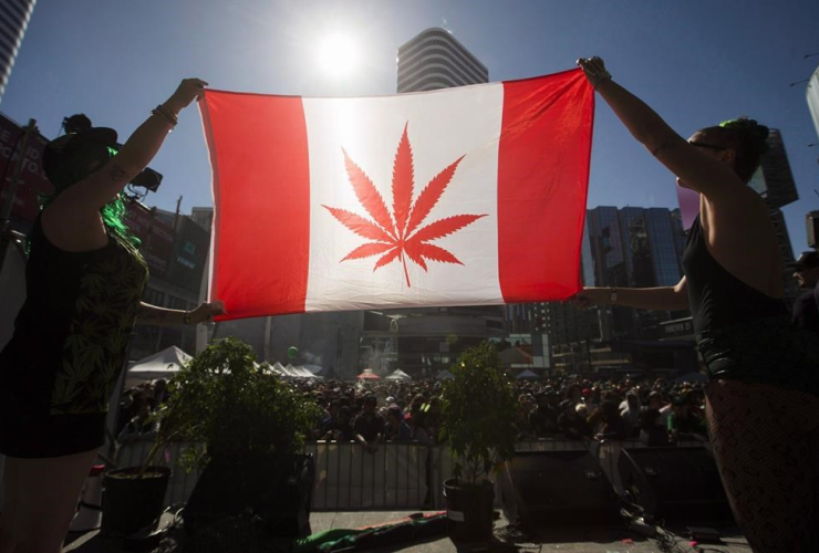 Two people hold a modified design of the Canadian flag with a marijuana leaf in place of the maple leaf during the "420 Toronto" rally in Toronto, April 20, 2016.