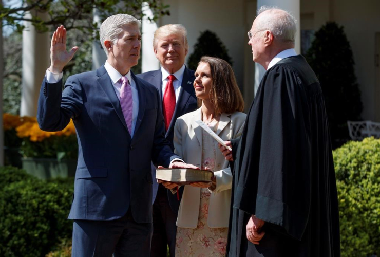 President Donald Trump watches as Supreme Court Justice Anthony Kennedy administers the judicial oath to Judge Neil Gorsuch during a re-enactment in the Rose Garden of the White House on April 10, 2017, in Washington.