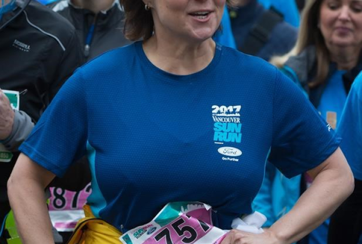 Liberal Leader Christy Clark ties her jacket around her waist as she jogs to the start line to participate in the Sun Run, in Vancouver, B.C., on Sunday April 23, 2017.