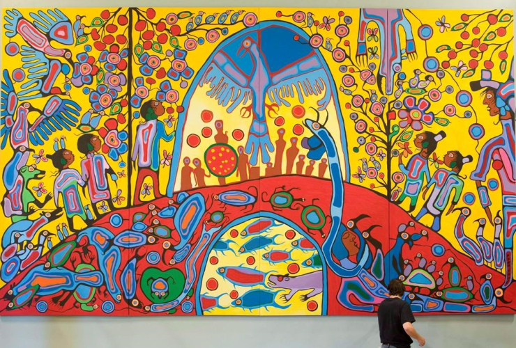 A worker installs Canadian Aboriginal artist Norval Morrisseau's painting "Androgyny" in the ballroom at Rideau Hall in Ottawa on Sept. 18, 2008. File photo by The Canadian Press/Adrian Wyld