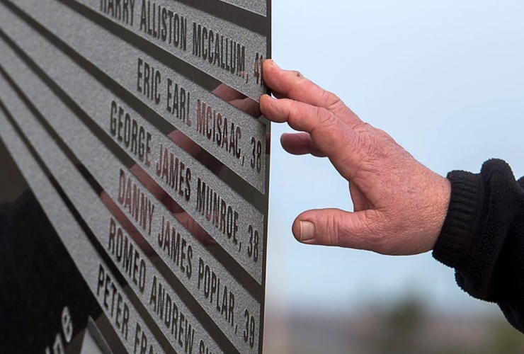 A hand touches the monument that honours the 26 coal miners who perished in the Westray mine disaster at the Westray Miners Memorial Park in New Glasgow, N.S. on Tuesday, May 9, 2017.