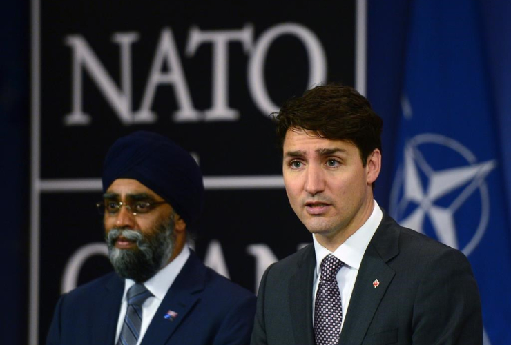 Minister of National Defence Minister Harjit Singh Sajjan stands with Prime Minister Justin Trudeau as he holds a press conference at NATO headquarters during the NATO Summit in Brussels, Belgium on May 25, 2017.