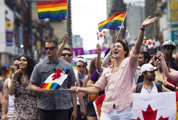 Prime Minister Justin Trudeau is splashed with water as he waves a flag at the annual Pride Parade in Toronto on Sunday, July 3, 2016. File photo by The Canadian Press/Nathan Denette