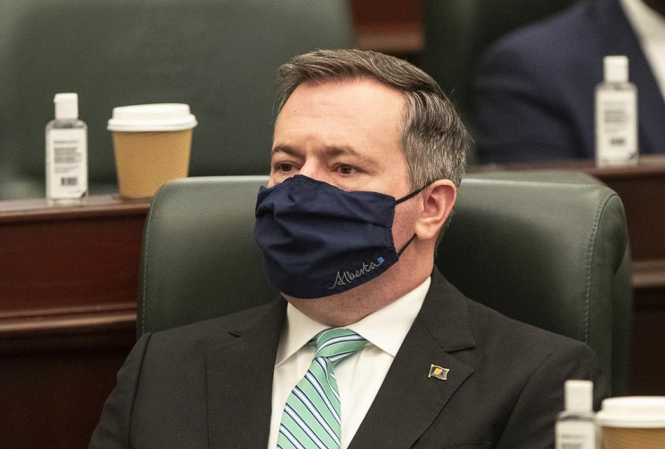 Man wearing a face mask sitting in a chair