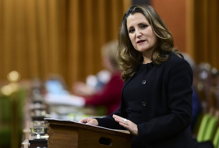 Woman stands at podium, speaking