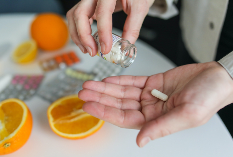 A person holds a pill in their hand.