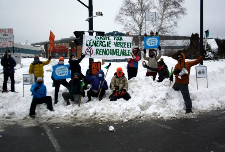 People protest in winter gear with signs