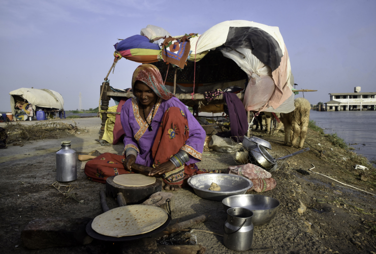 A woman in Pakitan cooks dinner outside her tent during the 2022 floods