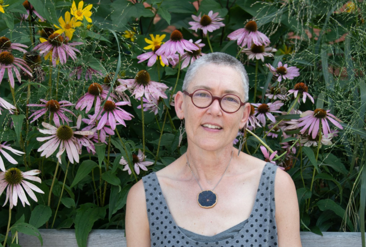 a woman sitting in front of wildflowers