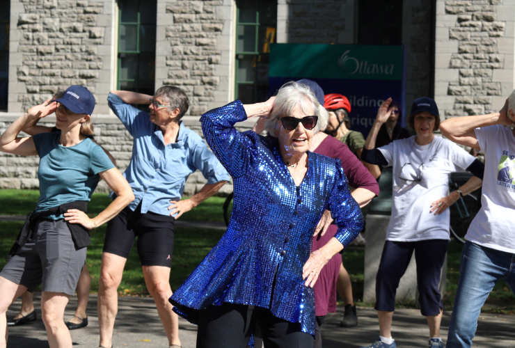 a group of people dance to the Bee Gees "Stayin' Alive"