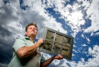 SolarWindow CEO John Conklin holds one of the company's specially coated windows. Photo by SolarWindow 