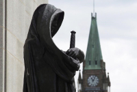 The Peace tower on Parliament Hill is seen behind the justice statue outside the Supreme Court of Canada in Ottawa, Monday June 6, 2016. File Photo by THe Canadian Press/Adrian Wyld 