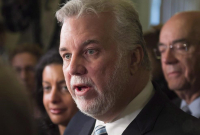 Quebec Premier Philippe Couillard, centre, speaks to reporters at a news conference to comment the Bombardier C-Series deal with Delta Airlines on Thursday, April 28, 2016 at the legislature in Quebec City.