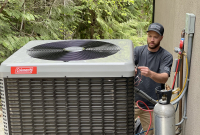 A male worker installs a heat pump outside a home