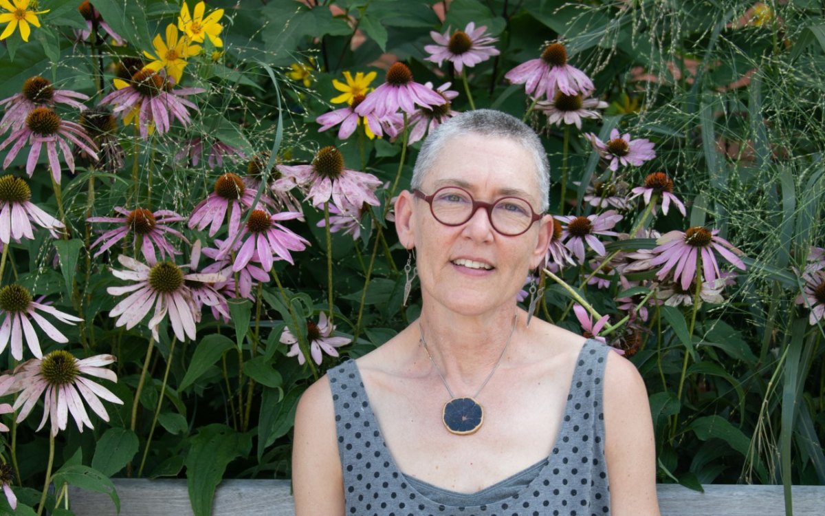 a woman sitting in front of wildflowers