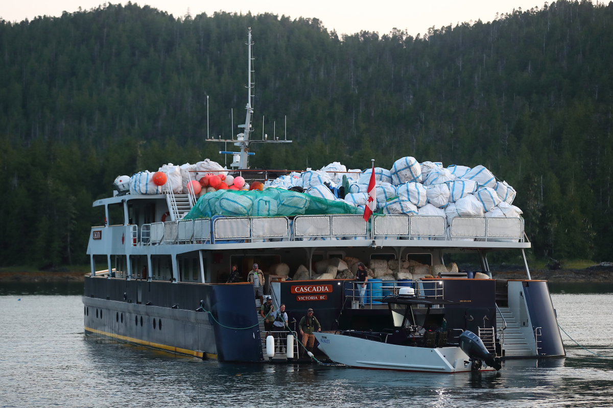 a catamaran piled high with bags of marine debris and plastic