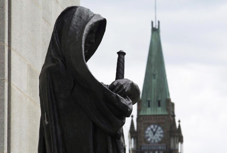 The Peace tower on Parliament Hill is seen behind the justice statue outside the Supreme Court of Canada in Ottawa, Monday June 6, 2016. File Photo by THe Canadian Press/Adrian Wyld 