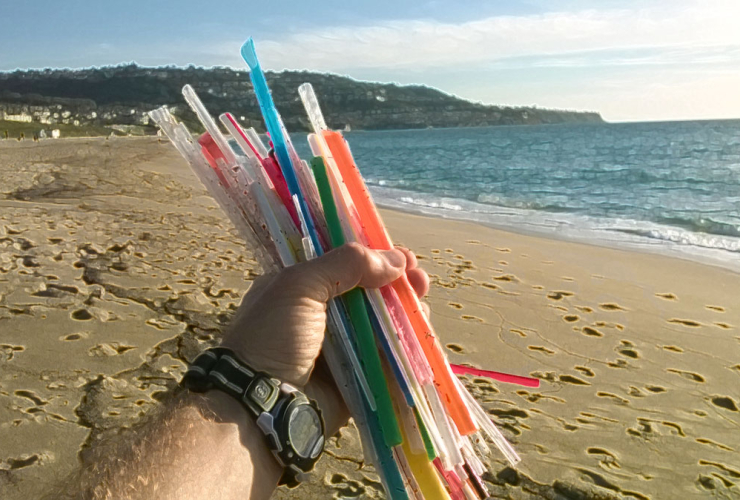 A fistful of 50 plastic straws found littered on the beach
