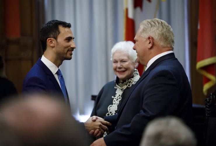 Ontario Premier Doug Ford shakes hands with minister Stephen Lecce as Lecce is sworn in as the Minister of Education
